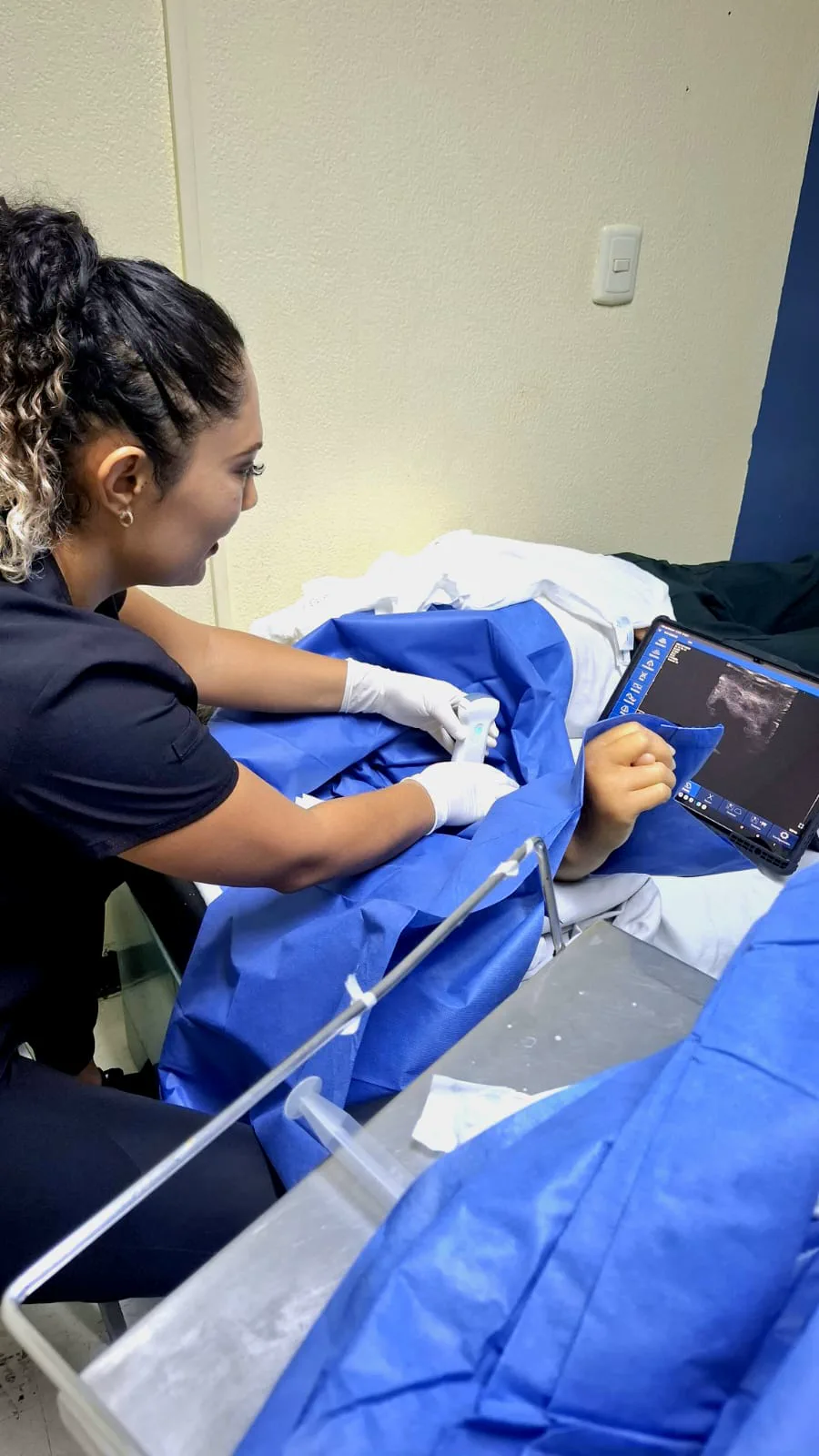 La Dra. Liliana Hernández realiza un rastreo con ultrasonido en el brazo de un paciente