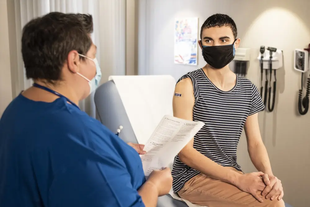 Profesional de salud en consulta con un paciente